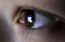Picture illustration shows Apple Inc's logo reflected in a person's eye, in central Bosnian town of Zenica